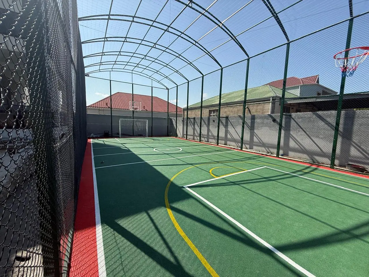 Yaşıl EPDM rezin örtüklü çoxfunksiyalı idman meydançası — qırmızı kənar zolaq, futbol və basketbol xətləri