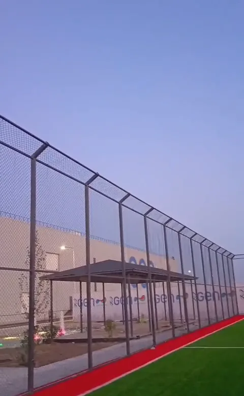 Mini stadionun polad dirəkli tor hasarı — axşam görünüşü