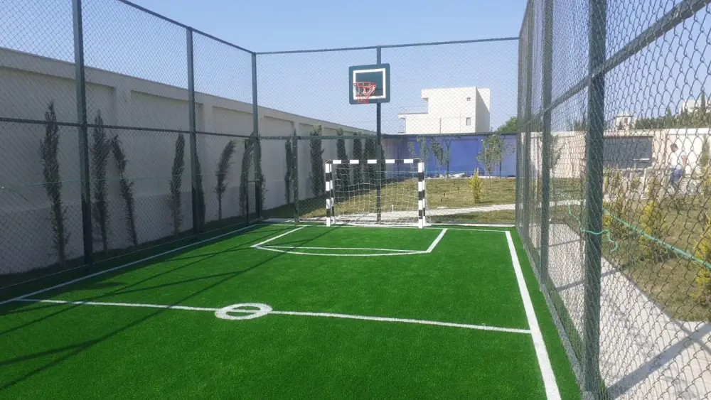 Süni qazon örtüklü mini futbol meydançası — futbol qapısı və basketbol lövhəsi ilə